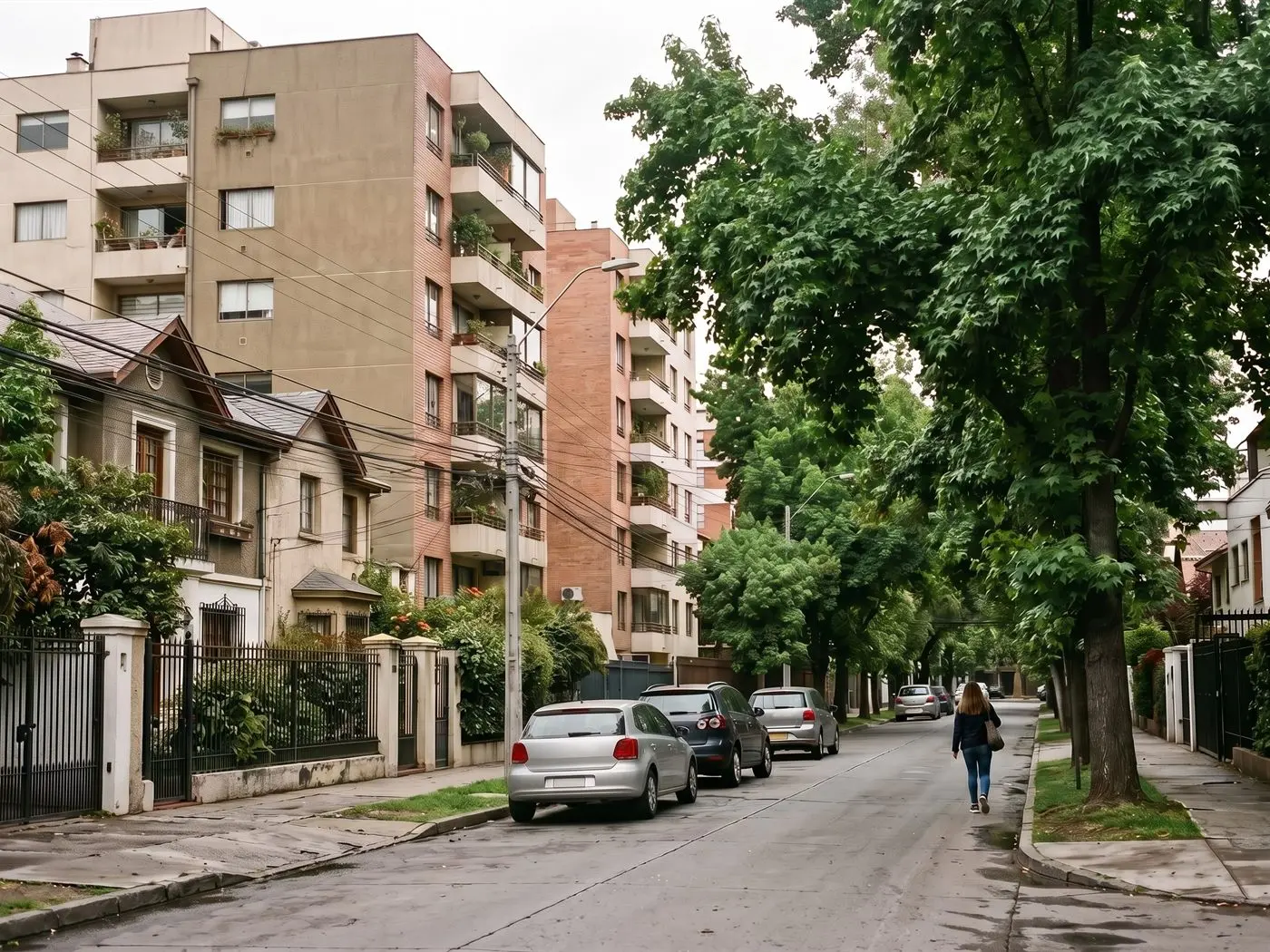 Edificios de departamentos de altura media y casas de dos pisos en una calle arbolada de Ñuñoa