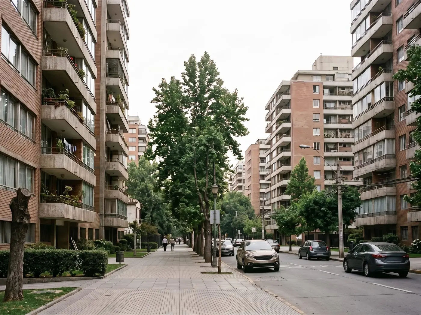 Edificios de departamentos de ladrillo con balcones, de los años setenta, en una avenida arbolada de Providencia