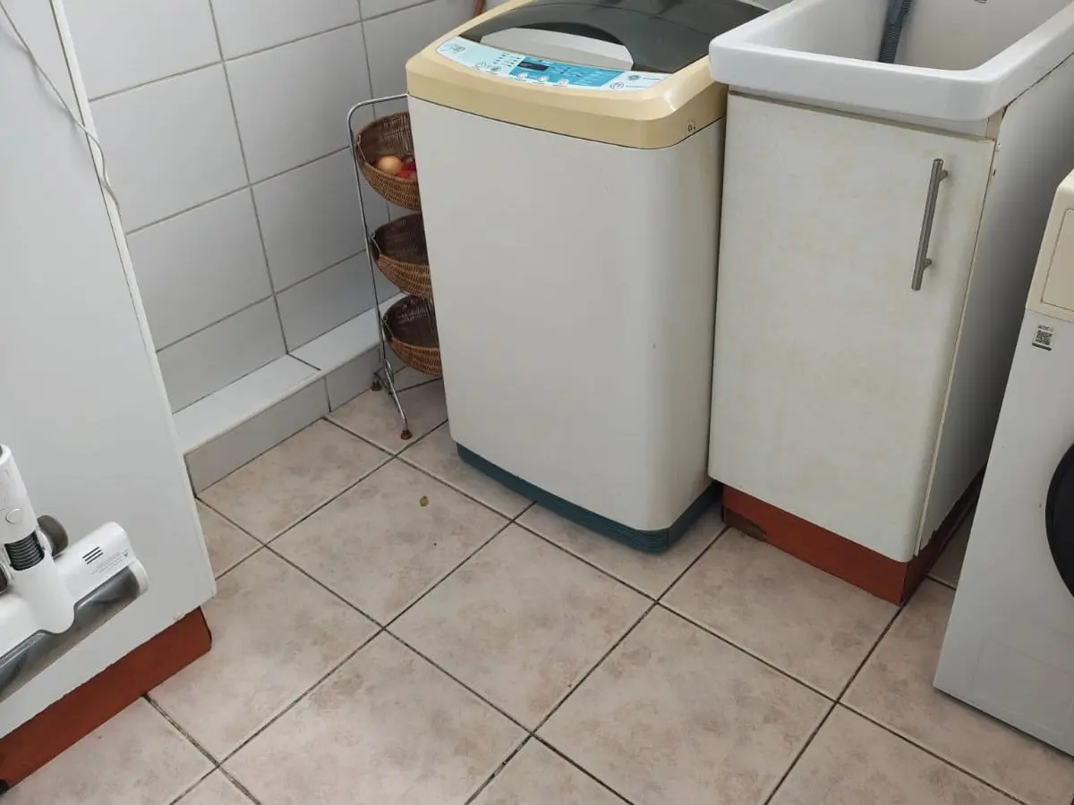 Logia de un depto con la lavadora y el lavadero en su lugar y el piso de cerámica limpio