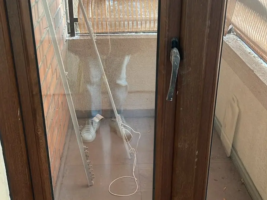 Puerta de vidrio con marco de madera que da a la terraza de un depto